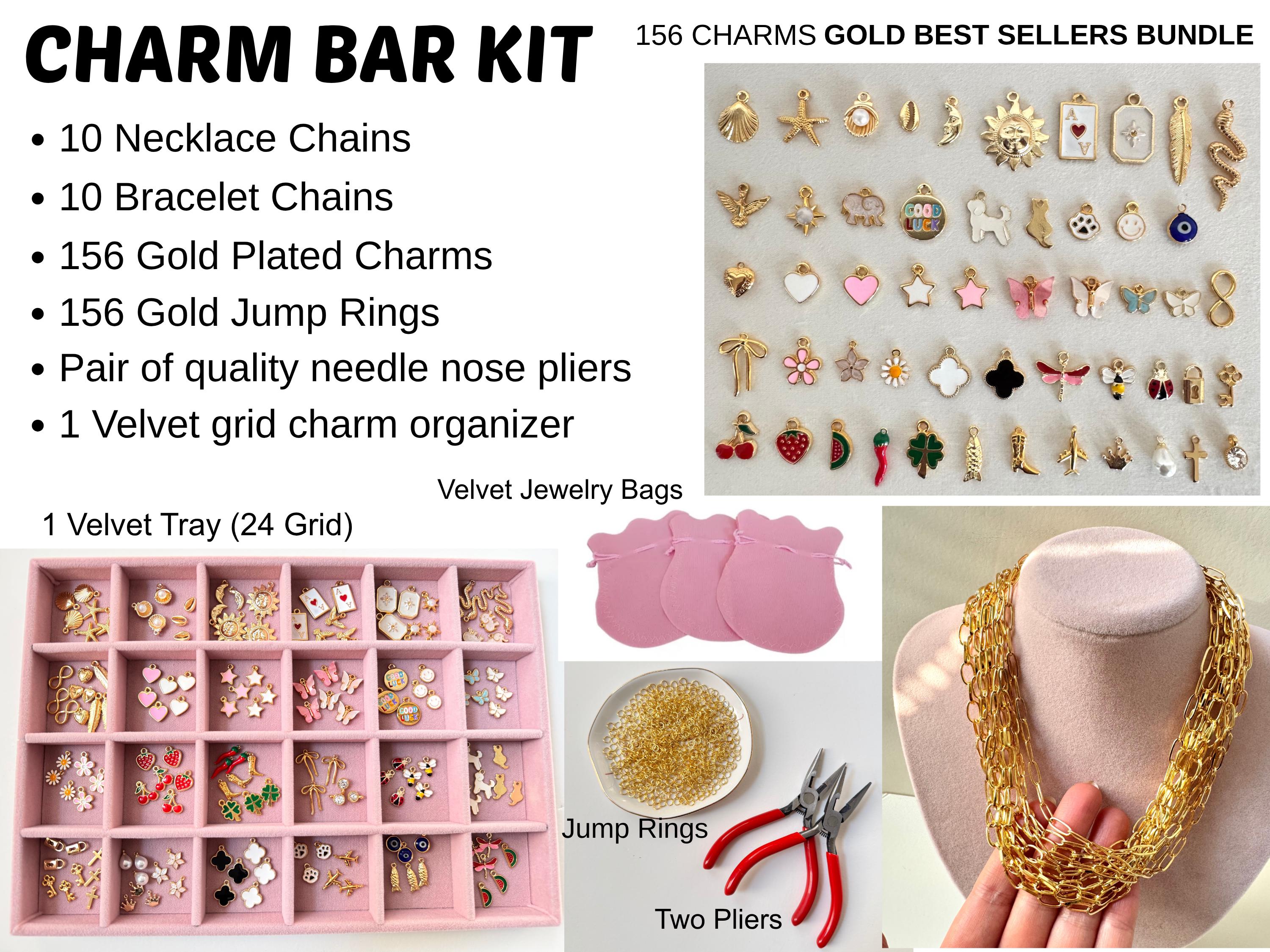 Professional Charm Bar Kit for Parties with 156 gold plated charms and 20 pre-assembled chains. The set includes a 24-grid pink velvet jewelry organizer tray, two red needle nose pliers, a pile of gold jump rings, and pink velvet jewelry bags. Displayed are assorted colorful charms, a thick paperclip chain necklace, and a complete DIY jewelry making station."